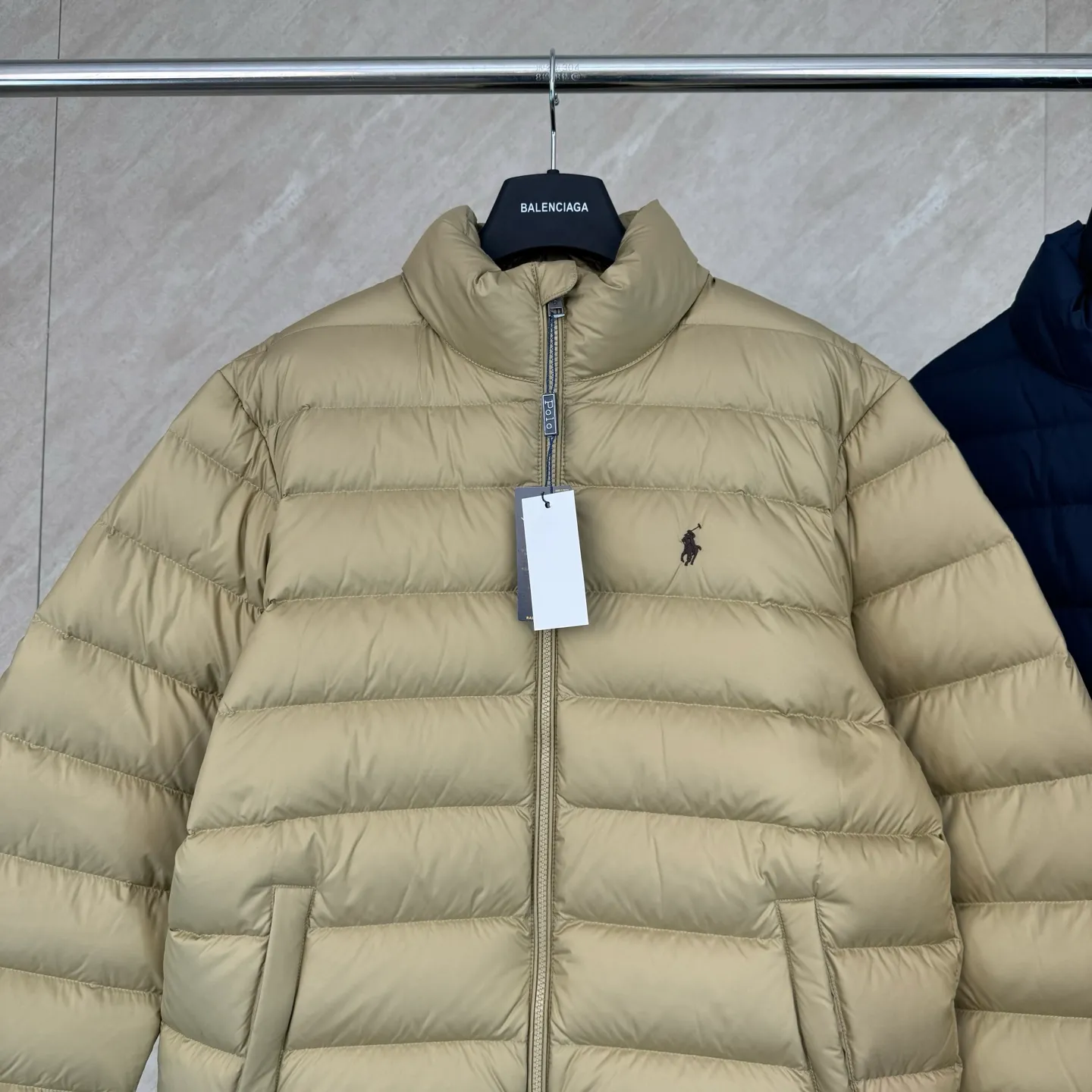 P930 Ralph Lauren lightweight down jacket size s m l xl The nylon fabric has good windproof and waterproof properties, which can effectively block the intrusion of wind and rain from the outside and keep the inside dry, suitable for wearing in humid or rainy environments.  The red label on the chest is made with an imported MECLO embroidery machine. The original pattern is scanned first, and then high-quality silk thread is used to make a pattern. The density effect is adjusted by continuous pattern making.  Exquisite details: the zipper design is simple and elegant, easy to operate; the closing design of the cuffs and hem effectively prevents the intrusion of cold wind, improving the warmth and comfort of wearing.  High-quality filling: 90 white duck down is selected, with a weight of 260g, ensuring excellent thermal insulation performance. After strict screening and processing, the velvet is not easy to drill, ensuring durability. The hangtags, wash marks, air holes, and four-button buttons are all customized from the original one-to-one mold.